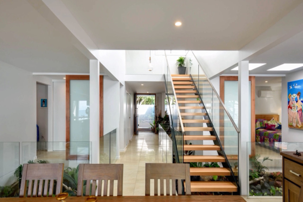 This is an example of a beach style wood straight staircase in Sunshine Coast with open risers.