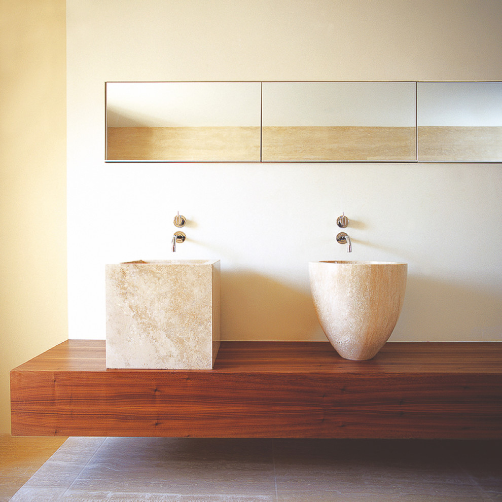 Photo of a large contemporary master wet room bathroom in London with glass-front cabinets, an undermount tub, a wall-mount toilet, white walls, limestone floors, a vessel sink, wood benchtops, beige floor and an open shower.