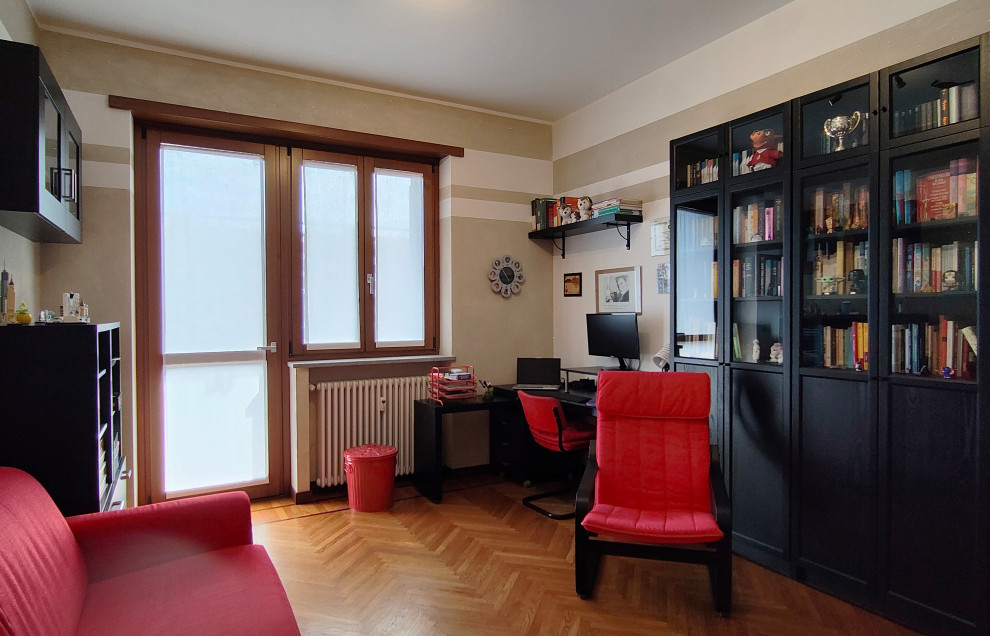 Foto di un grande studio minimalista con libreria, pareti multicolore, parquet chiaro, scrivania autoportante e pavimento marrone