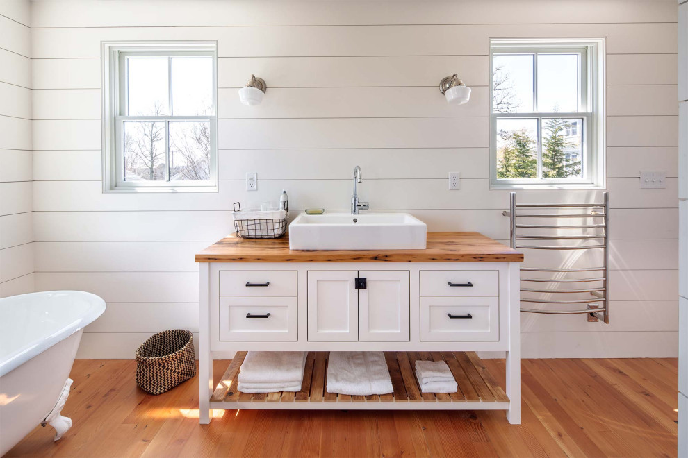 Mid-sized transitional bathroom in Boston with white cabinets, a claw-foot tub, white walls, a drop-in sink, brown floor, brown benchtops, a single vanity, shaker cabinets, medium hardwood floors, wood benchtops, a built-in vanity and planked wall panelling.