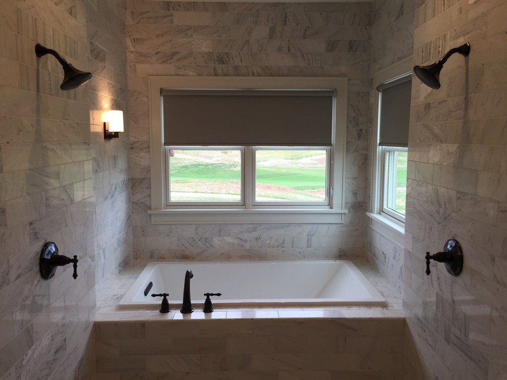 Photo of a mid-sized transitional master bathroom in Other with a drop-in tub, a double shower and gray tile.