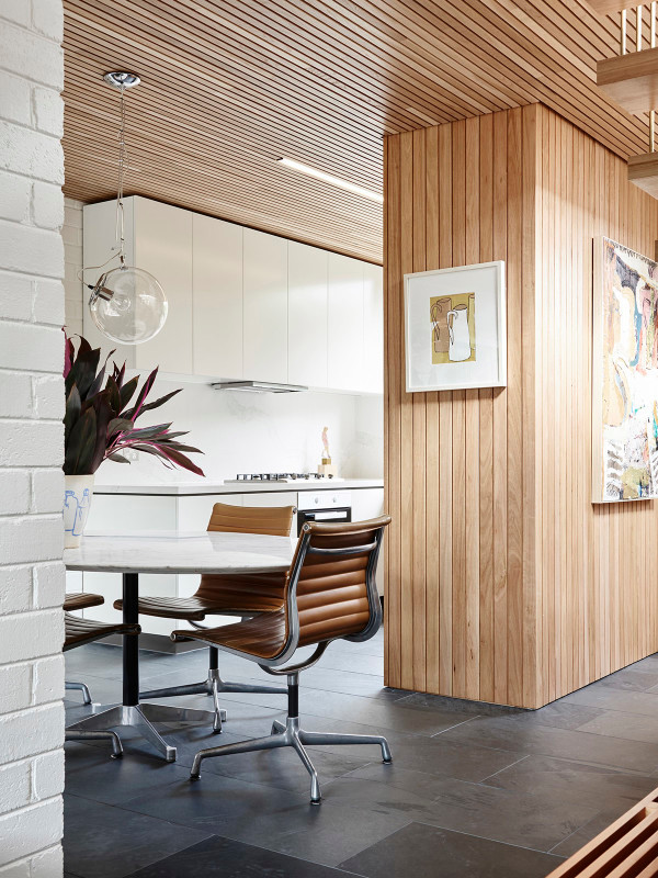 This is an example of a small midcentury open plan dining in Melbourne with white walls, slate floors and grey floor.