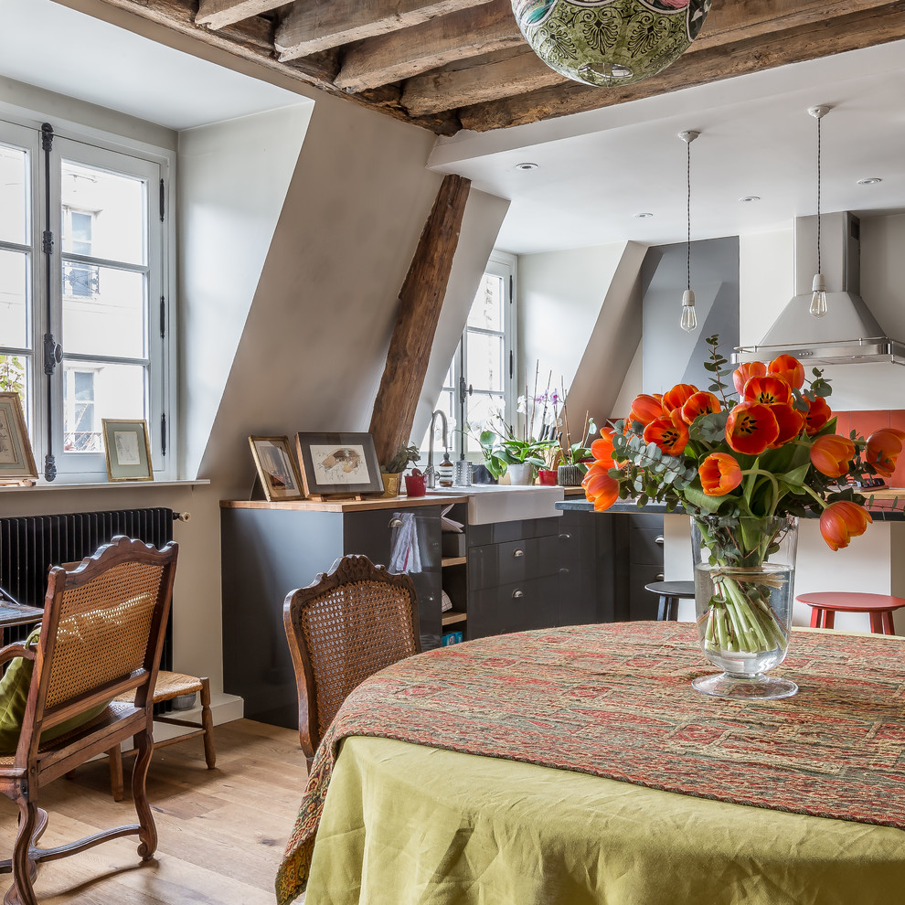 Photo of a mediterranean open plan dining in Paris with white walls, medium hardwood floors and brown floor.
