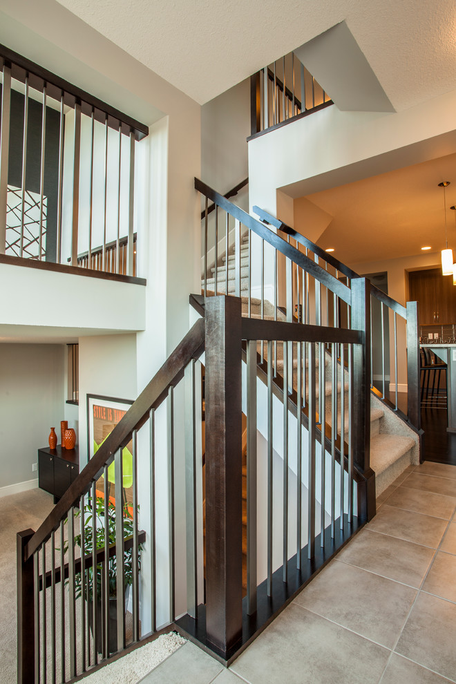 Design ideas for a modern carpeted straight staircase in Calgary with carpet risers.