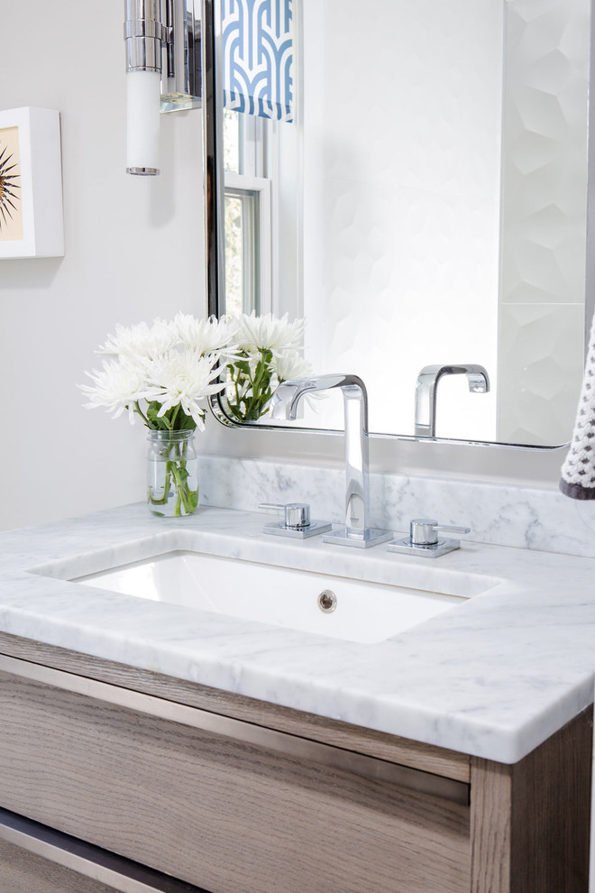 Inspiration for a small contemporary powder room in Denver with flat-panel cabinets, light wood cabinets, a one-piece toilet, white tile, ceramic tile, grey walls, porcelain floors, an undermount sink, marble benchtops, grey floor and white benchtops.