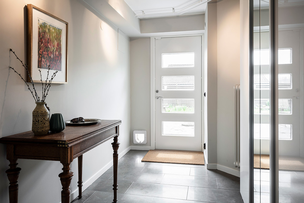 Inspiration for a mid-sized scandinavian walk-out basement in Gothenburg with beige walls, limestone floors and grey floor.