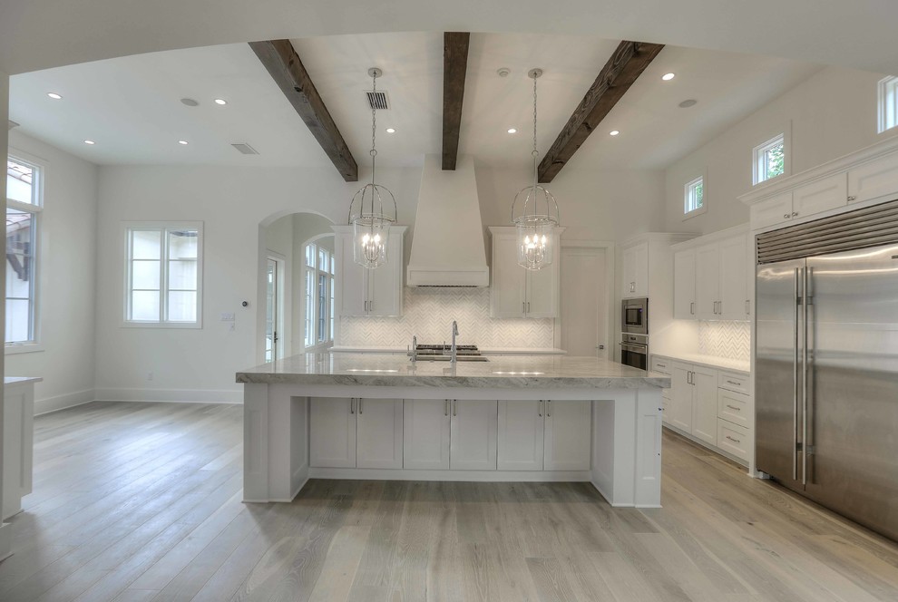 Kitchen - huge transitional light wood floor kitchen idea in Austin with an undermount sink, white cabinets, beige backsplash, stainless steel appliances and an island