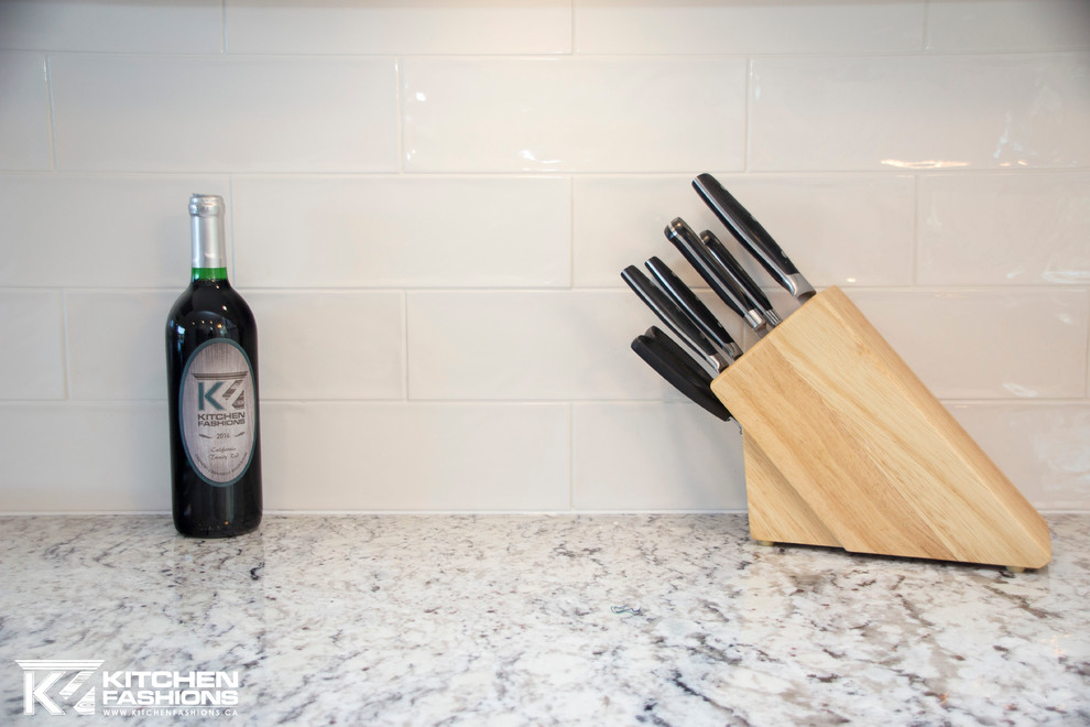 Home design - large transitional u-shaped light wood floor home design idea with a farmhouse sink, shaker cabinets, white cabinets, granite countertops, white backsplash, subway tile backsplash, stainless steel appliances and no island