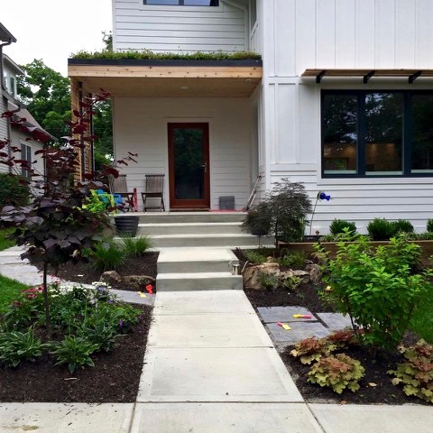 Photo of a mid-sized contemporary front yard formal garden in Indianapolis with a container garden and natural stone pavers.