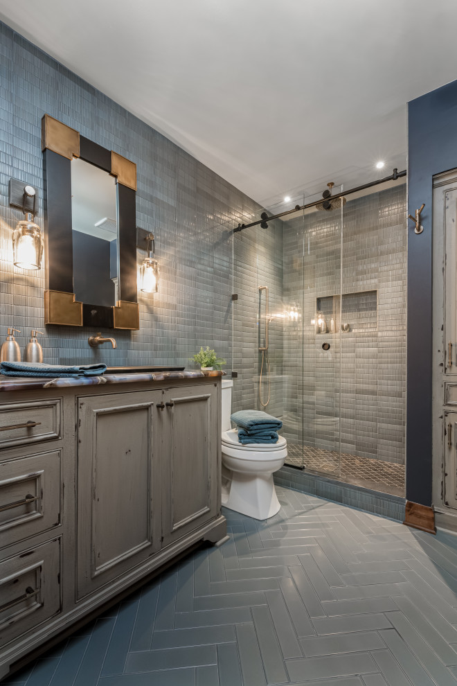 Inspiration for a large transitional bathroom in Milwaukee with an alcove shower, a two-piece toilet, gray tile, blue walls, marble benchtops, a sliding shower screen, a single vanity, a built-in vanity, beaded inset cabinets, distressed cabinets, mosaic tile, a drop-in sink, grey floor and multi-coloured benchtops.