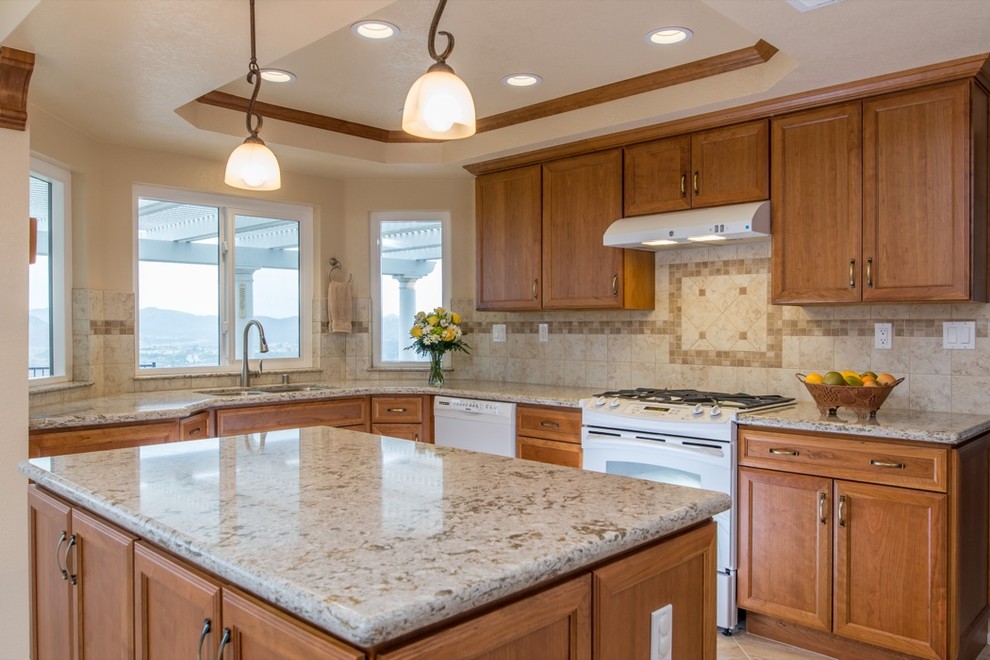 Inspiration for a traditional u-shaped eat-in kitchen in San Diego with a drop-in sink, recessed-panel cabinets, medium wood cabinets, granite benchtops, beige splashback and white appliances.