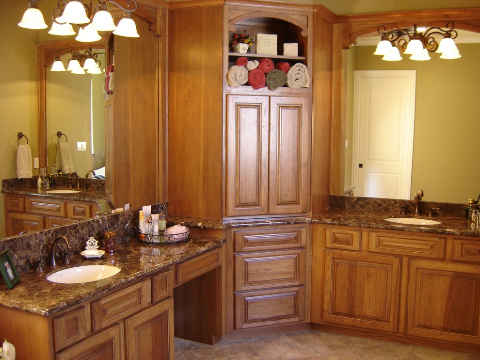 This is an example of a traditional bathroom in Houston with raised-panel cabinets, marble benchtops, porcelain tile and porcelain floors.