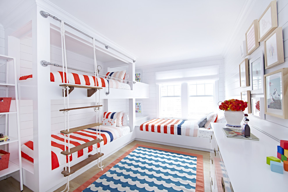Mid-sized beach style gender-neutral light wood floor kids' room photo in New York with white walls