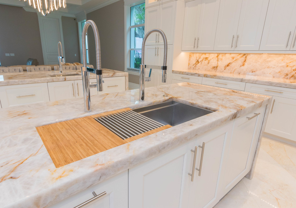 Inspiration for a huge transitional u-shaped marble floor and white floor open concept kitchen remodel with an undermount sink, flat-panel cabinets, white cabinets, quartzite countertops, white backsplash, stone slab backsplash and two islands