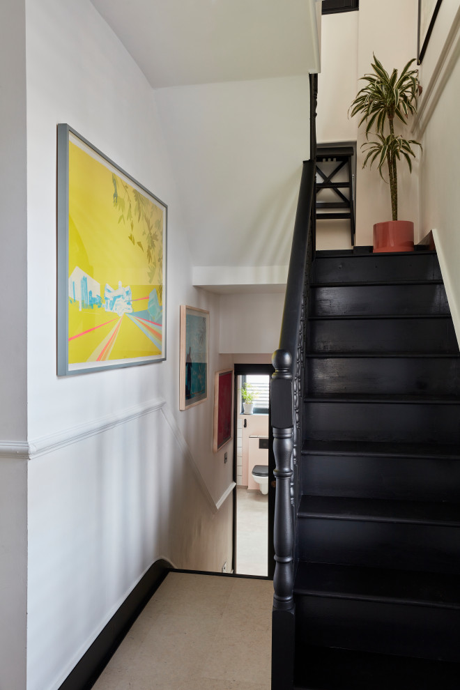 Cette image montre un escalier peint bohème de taille moyenne avec des marches en bois peint et un garde-corps en bois.