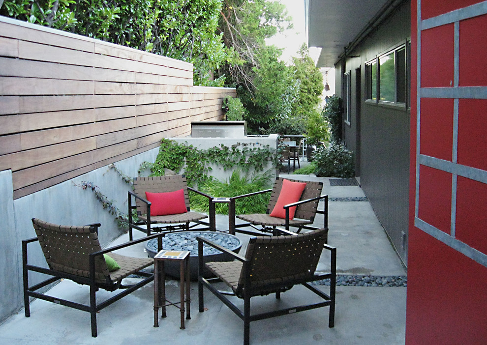 This is an example of a midcentury backyard patio in Seattle with a fire feature.