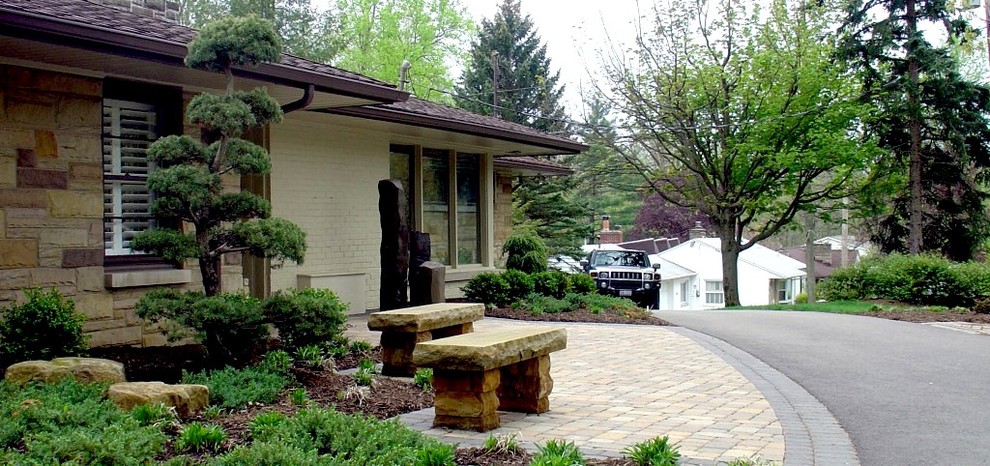 Photo of a large modern front yard partial sun garden in Cleveland with a container garden and brick pavers.