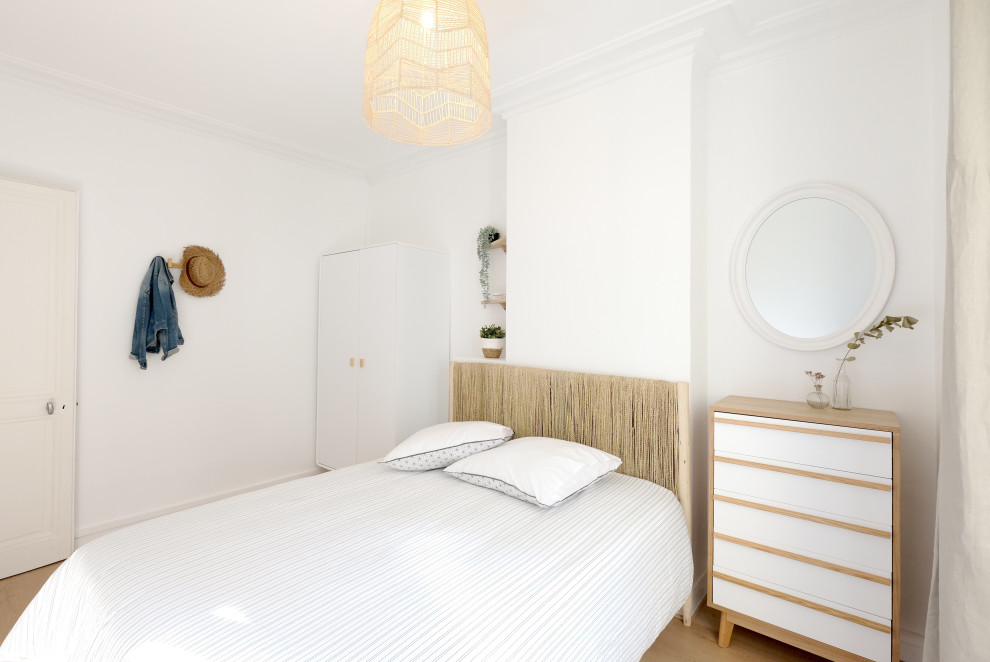 Diseño de dormitorio escandinavo pequeño con paredes blancas y suelo de madera clara