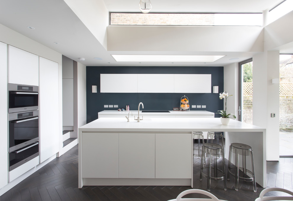 Inspiration for a contemporary kitchen in London with flat-panel cabinets and dark hardwood floors.