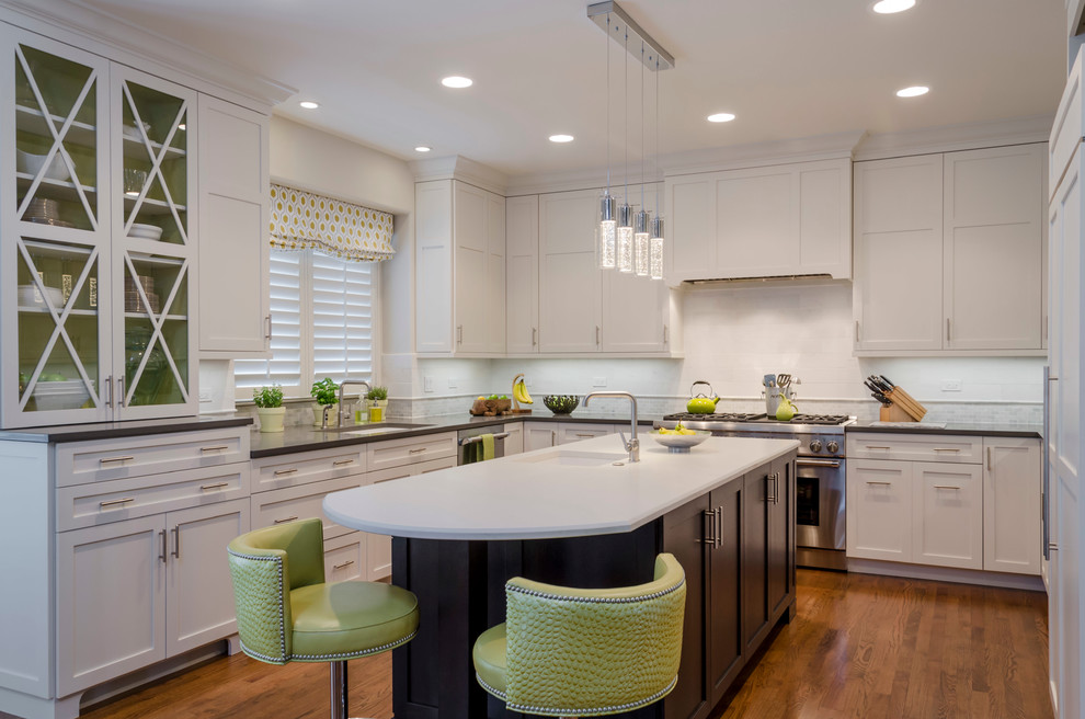 Example of a mid-sized transitional galley medium tone wood floor eat-in kitchen design in Chicago with a drop-in sink, glass-front cabinets, white cabinets, marble countertops, white backsplash, ceramic backsplash and an island