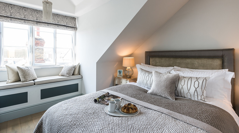 Design ideas for a transitional master bedroom in London with white walls.