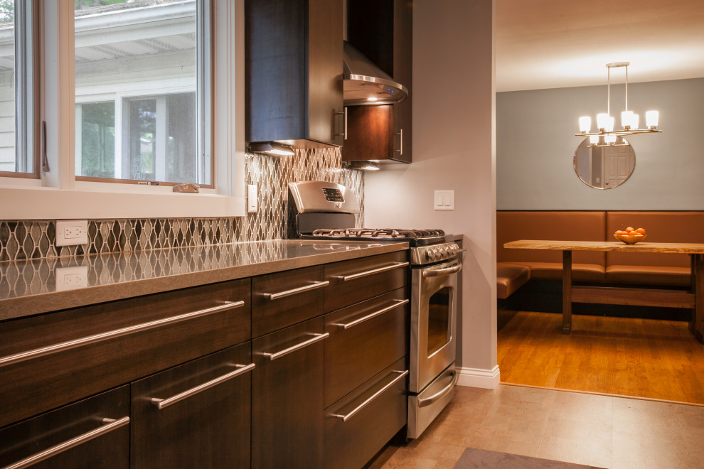 Transitional galley cork floor and gray floor eat-in kitchen photo with an undermount sink, flat-panel cabinets, dark wood cabinets, quartz countertops, mosaic tile backsplash, stainless steel appliances and a peninsula