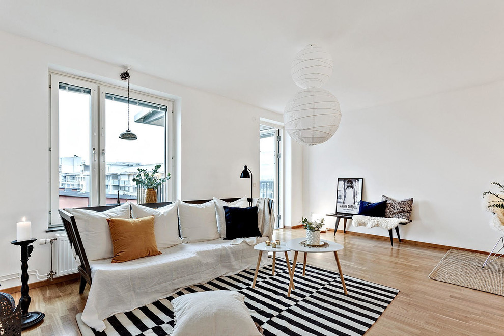 Photo of a mid-sized scandinavian formal open concept living room in Orebro with white walls and light hardwood floors.