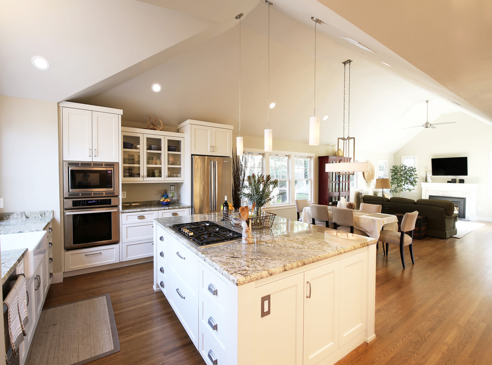 Design ideas for a mid-sized contemporary l-shaped open plan kitchen in Sacramento with a farmhouse sink, recessed-panel cabinets, white cabinets, granite benchtops, stone slab splashback, stainless steel appliances, medium hardwood floors, with island, brown floor and green benchtop.