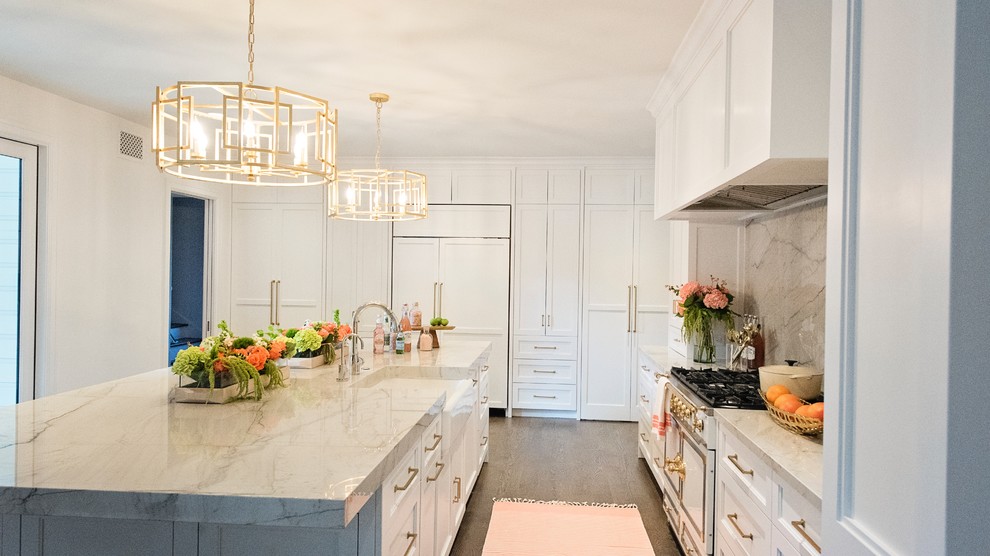 Inspiration for a large transitional l-shaped medium tone wood floor and brown floor open concept kitchen remodel with a farmhouse sink, recessed-panel cabinets, white cabinets, quartzite countertops, white backsplash, stone slab backsplash, paneled appliances and an island