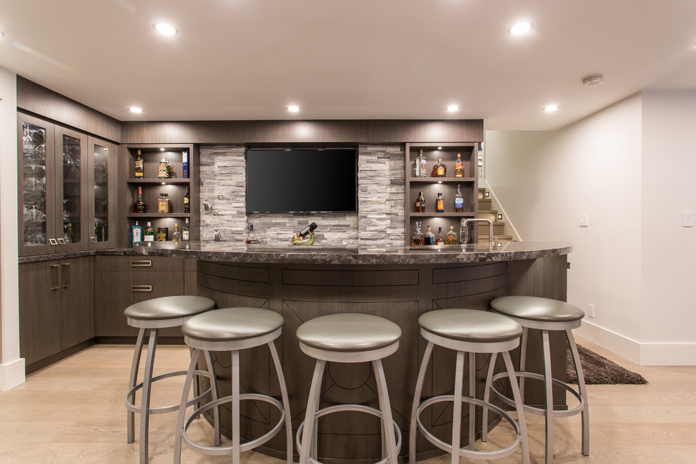 Inspiration for a large traditional single-wall seated home bar in Vancouver with flat-panel cabinets, brown cabinets, medium hardwood floors and grey floor.