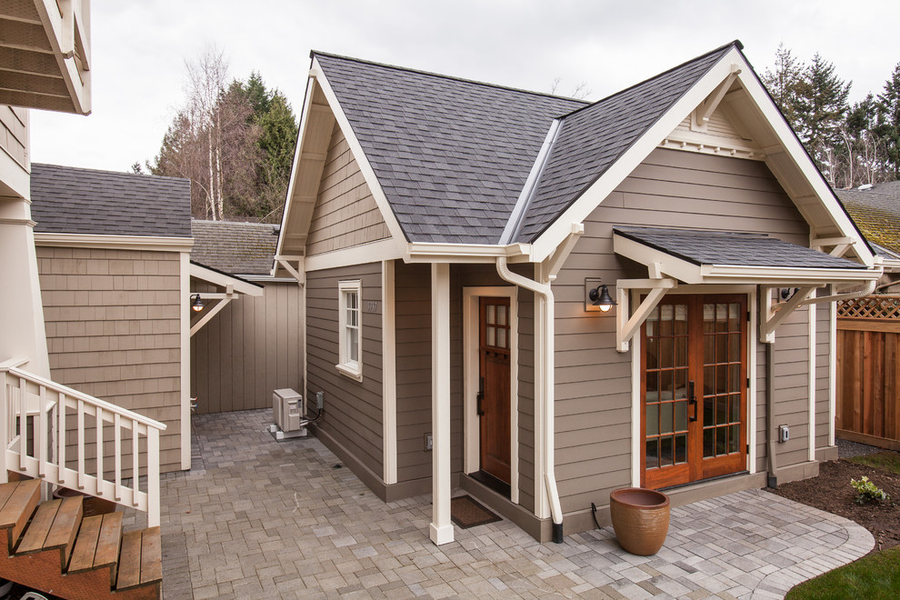 Photo of a small arts and crafts one-storey multi-coloured house exterior in Portland with concrete fiberboard siding, a hip roof and a shingle roof.