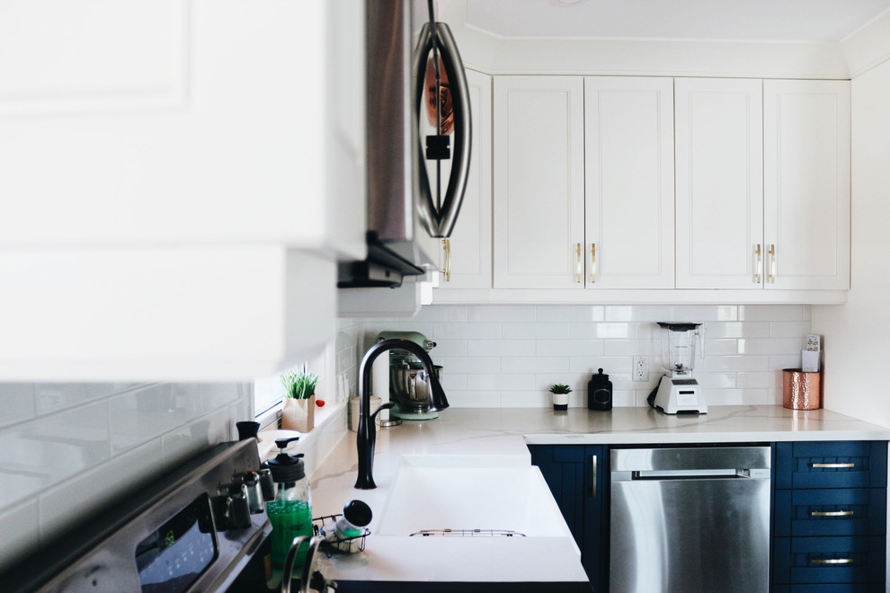 Inspiration for a mid-sized transitional u-shaped porcelain tile and multicolored floor eat-in kitchen remodel in Toronto with a farmhouse sink, beaded inset cabinets, blue cabinets, quartzite countertops, white backsplash, ceramic backsplash, stainless steel appliances, no island and multicolored countertops