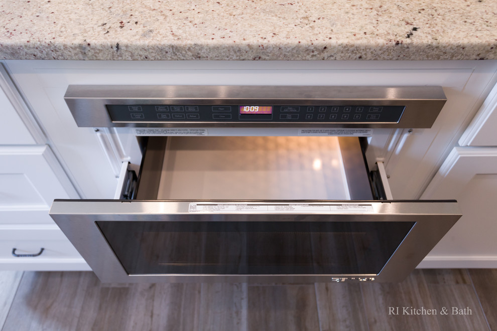 Example of a large transitional l-shaped porcelain tile eat-in kitchen design in Providence with an undermount sink, recessed-panel cabinets, white cabinets, granite countertops, gray backsplash, ceramic backsplash, stainless steel appliances, green walls and an island
