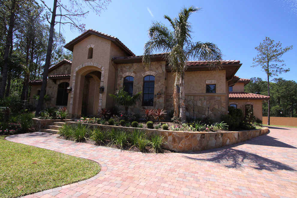 Large mediterranean two-storey beige exterior in Houston with mixed siding.