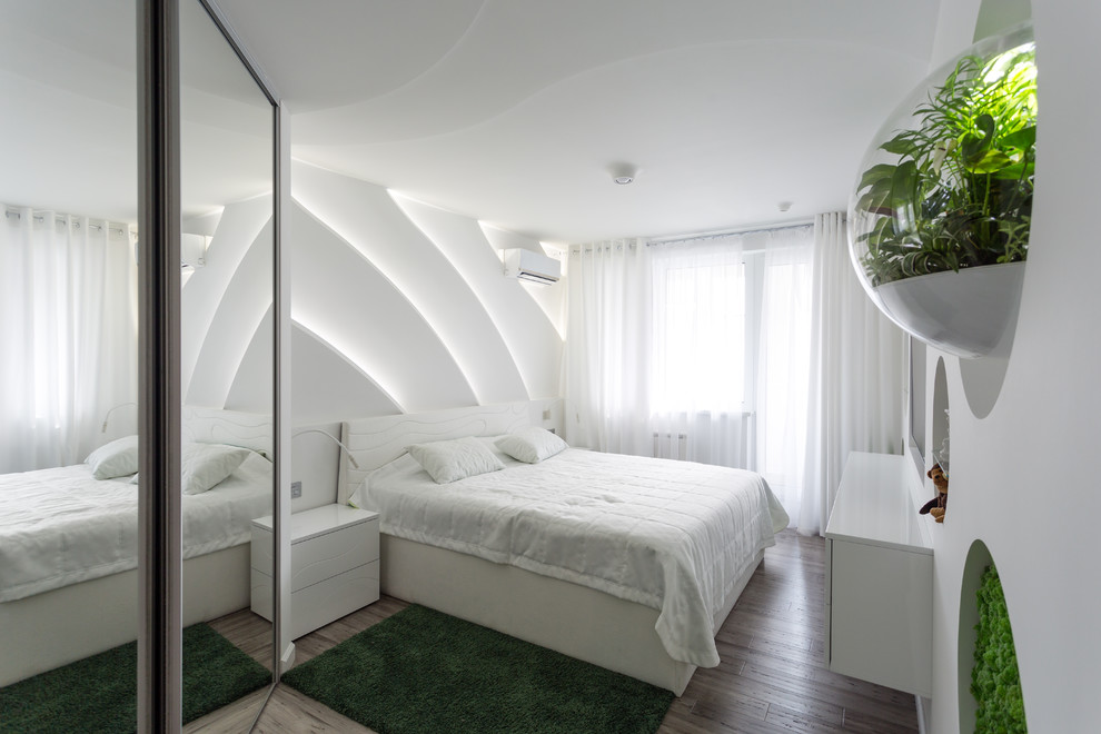 This is an example of a mid-sized contemporary master bedroom in Moscow with white walls, bamboo floors, no fireplace and grey floor.