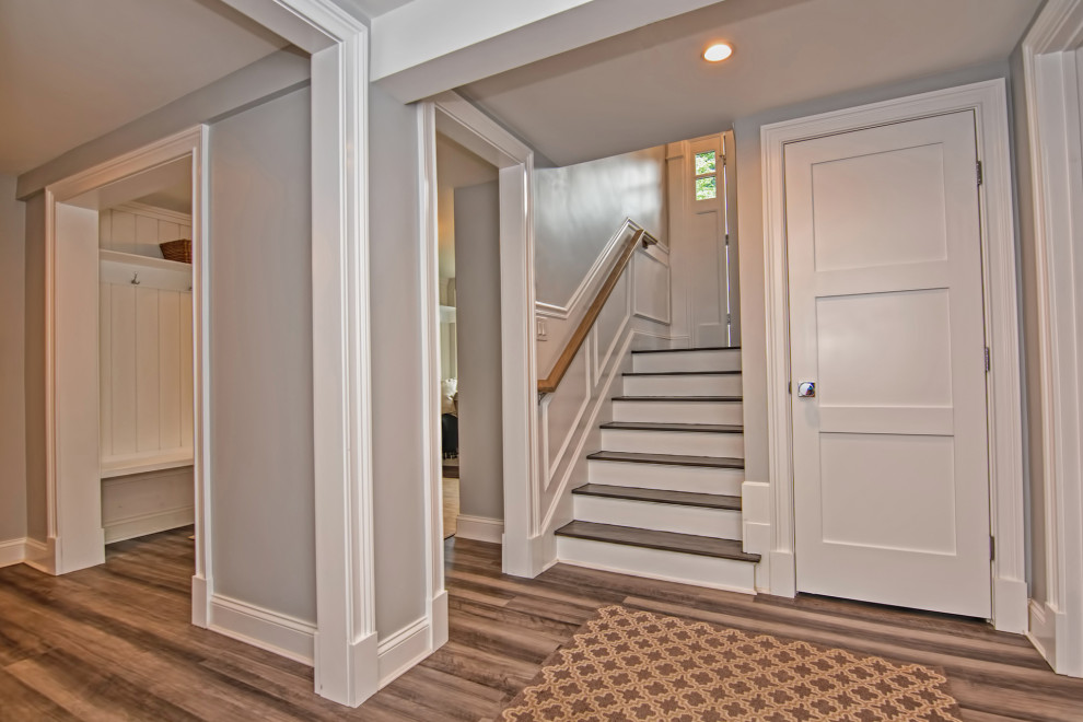 Imagen de recibidores y pasillos clásicos renovados pequeños con paredes grises, suelo laminado, suelo marrón y panelado