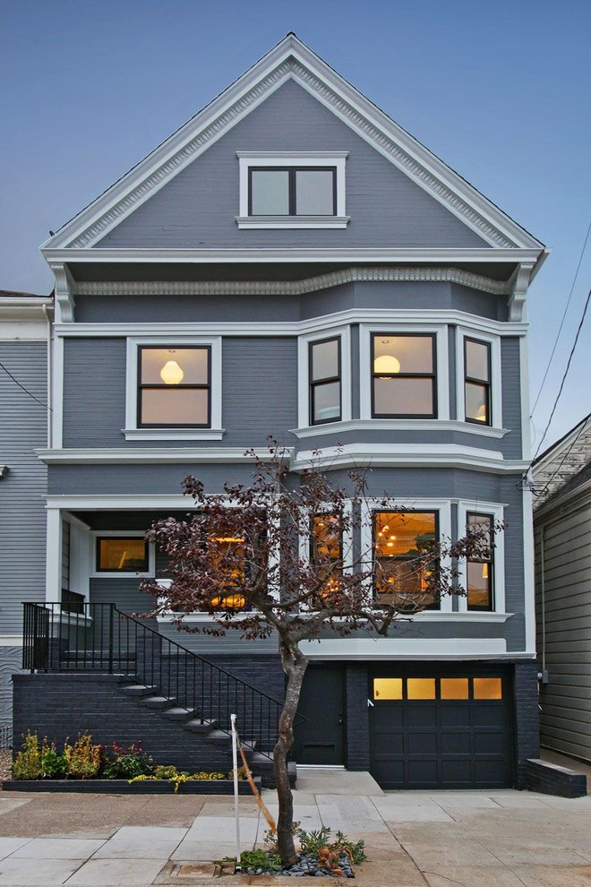 This is an example of a large transitional three-storey blue house exterior in San Francisco with wood siding, a gable roof and a shingle roof.