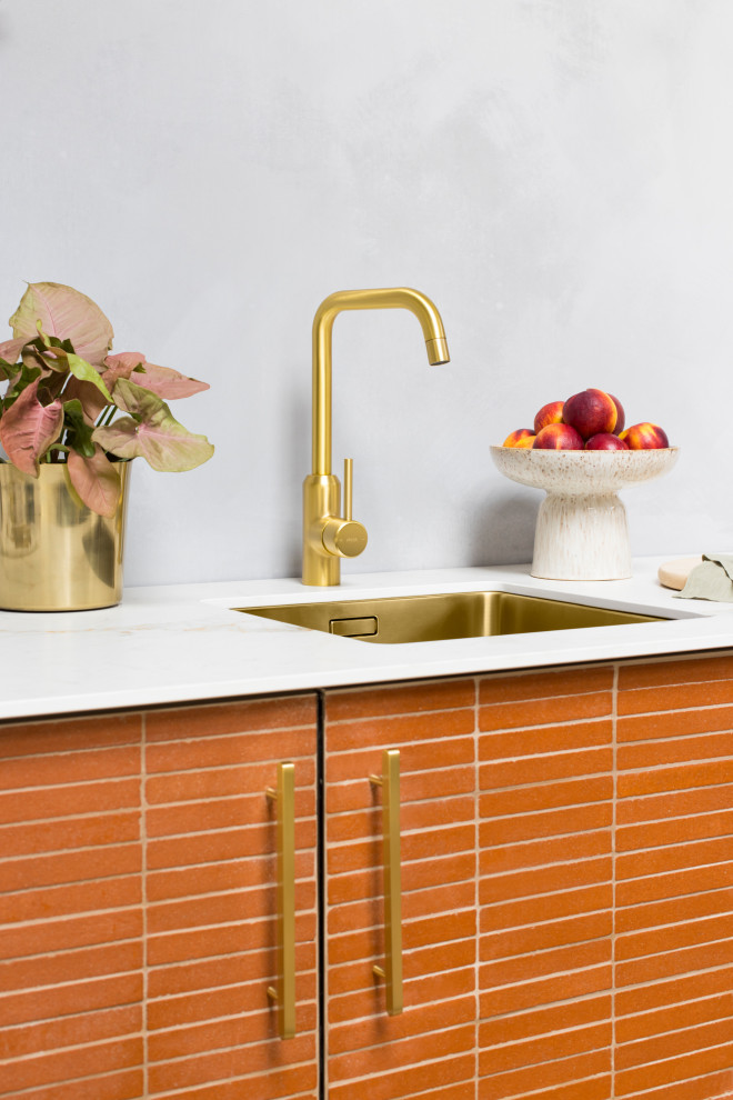 Idee per una piccola cucina moderna con lavello a vasca singola, ante lisce, ante arancioni, top in marmo, paraspruzzi grigio, paraspruzzi in lastra di pietra e top grigio