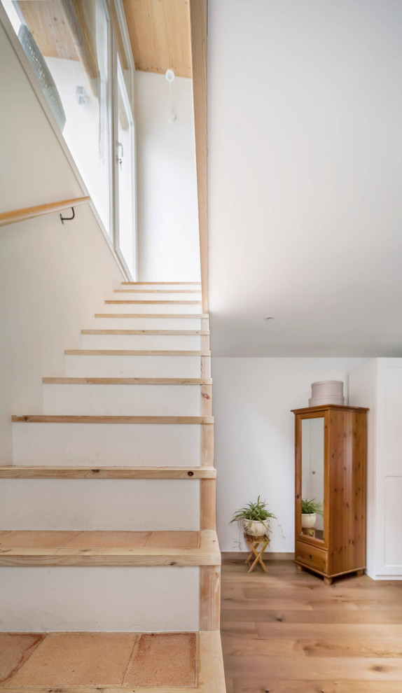 На фото: маленькая прямая лестница в современном стиле с ступенями из терракотовой плитки, крашенными деревянными подступенками и металлическими перилами для на участке и в саду с