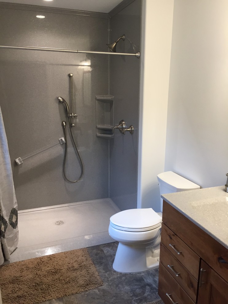 Small transitional 3/4 bathroom in Other with raised-panel cabinets, brown cabinets, a curbless shower, a two-piece toilet, beige walls, an integrated sink, onyx benchtops, grey floor and a shower curtain.