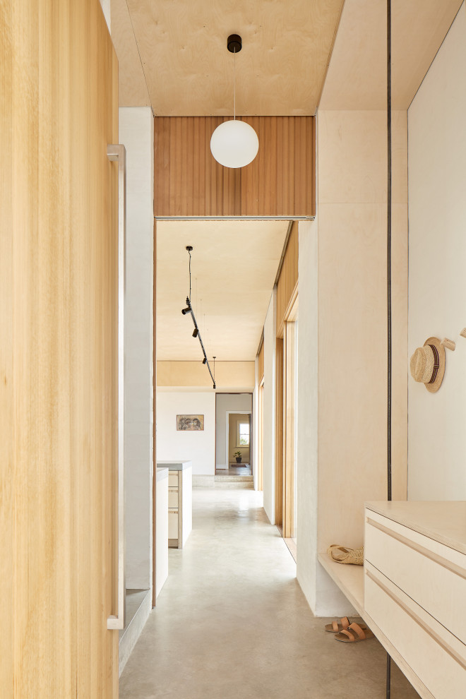 This is an example of a mid-sized contemporary hallway in Perth with concrete floors, grey floor and beige walls.