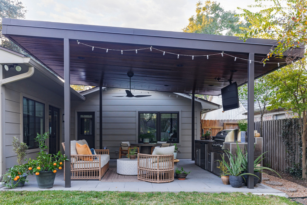 This is an example of a midcentury backyard patio in Houston with an outdoor kitchen, tile and a pergola.