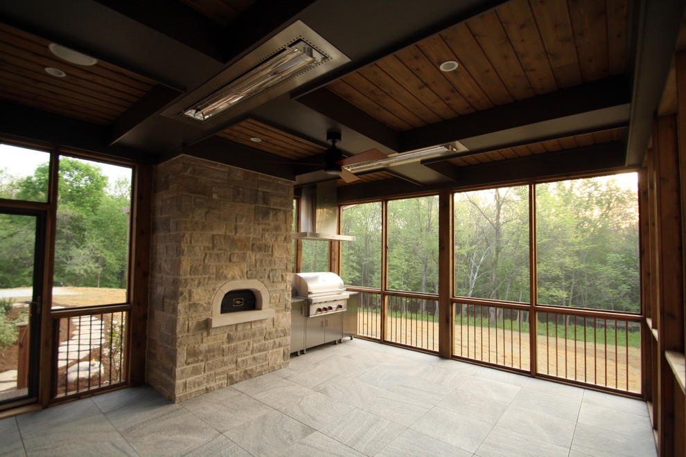 This is an example of a mid-sized country sunroom in Indianapolis with ceramic floors, a standard fireplace, a stone fireplace surround, a standard ceiling and beige floor.