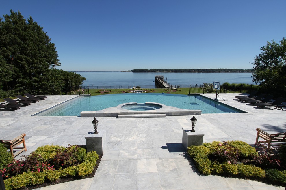 Large backyard stone and custom-shaped pool fountain photo in New York