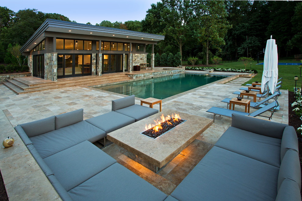 This is an example of a large contemporary backyard rectangular natural pool in DC Metro with a pool house and tile.