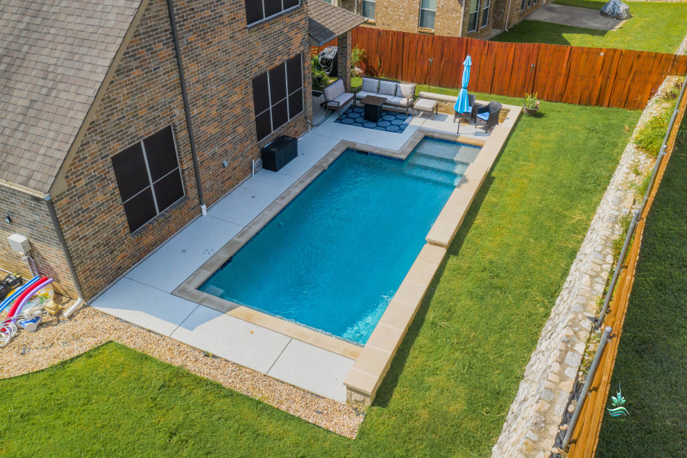 Mid-sized modern backyard l-shaped pool in Dallas with with privacy feature and stamped concrete.