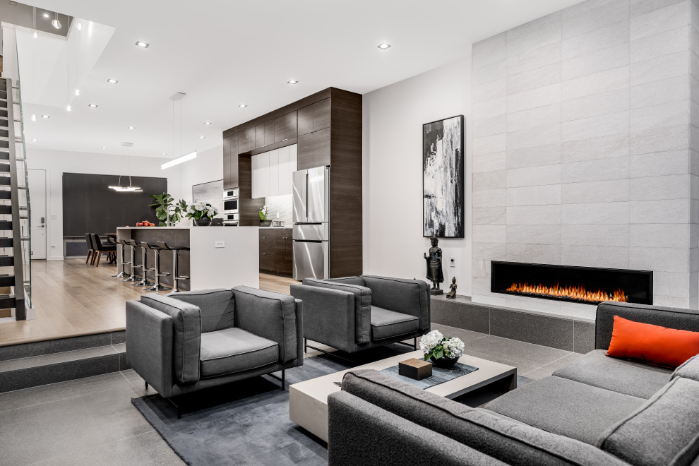 This is an example of a modern open concept living room in Philadelphia with white walls, porcelain floors, a ribbon fireplace, a tile fireplace surround and grey floor.