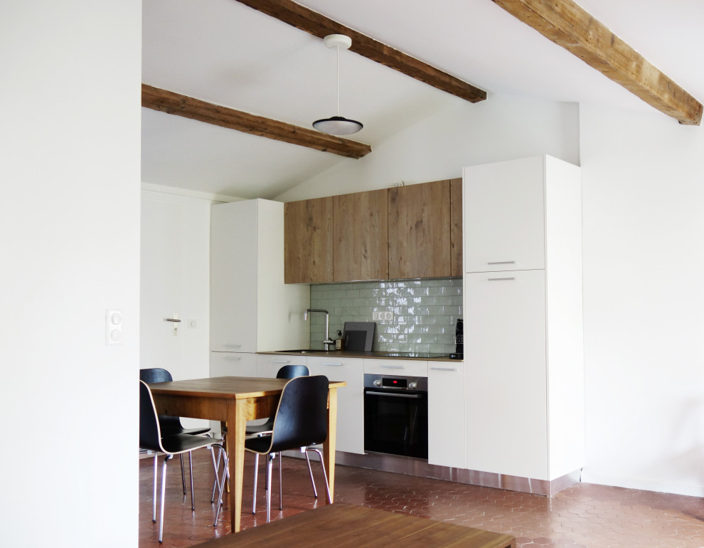 Exemple d'une cuisine blanche et bois industrielle avec un plan de travail en bois, une crédence verte, une crédence en carrelage métro et tomettes au sol.