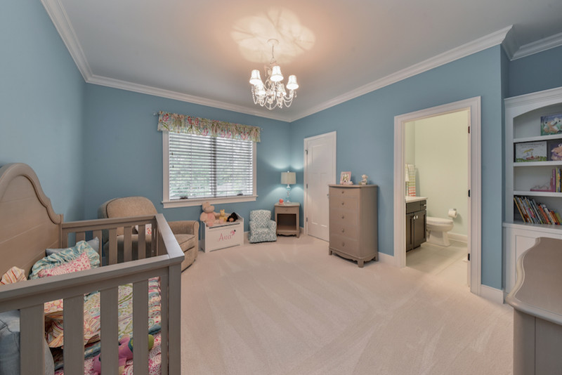 This is an example of a mid-sized arts and crafts nursery for girls in Chicago with blue walls and carpet.