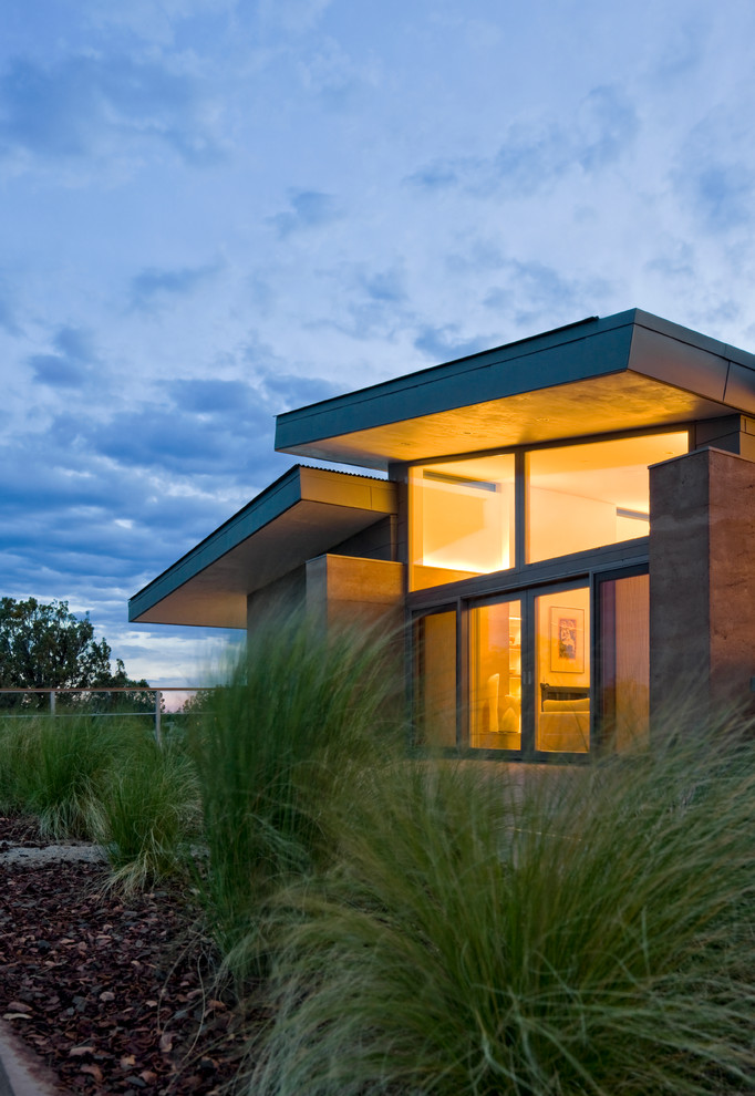 This is an example of a one-storey concrete house exterior in Denver with a shed roof.